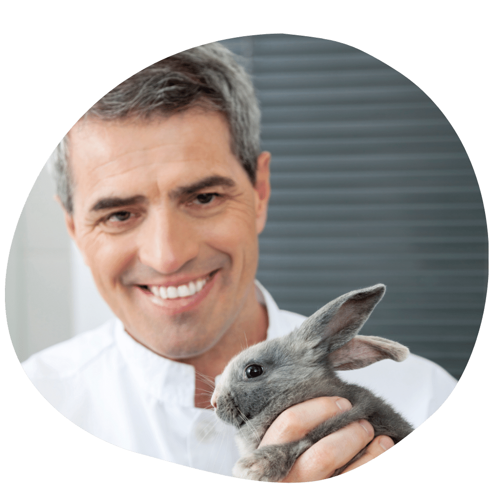 Rabbit parent holding a rabbit wearing a white coat availing Pawland’s pet boarding services