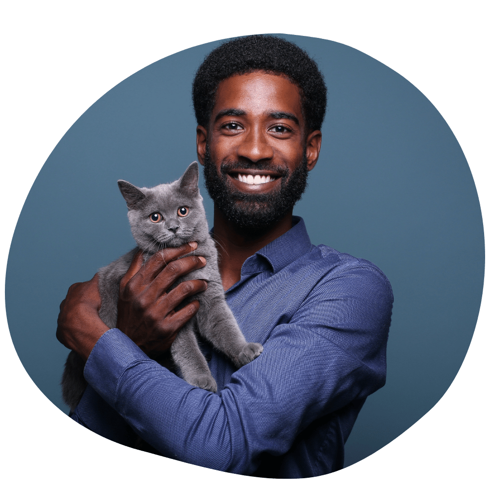 Cat parent wearing a blue shirt holding a grey cat after booking cat sitter in Dubai from Pawland