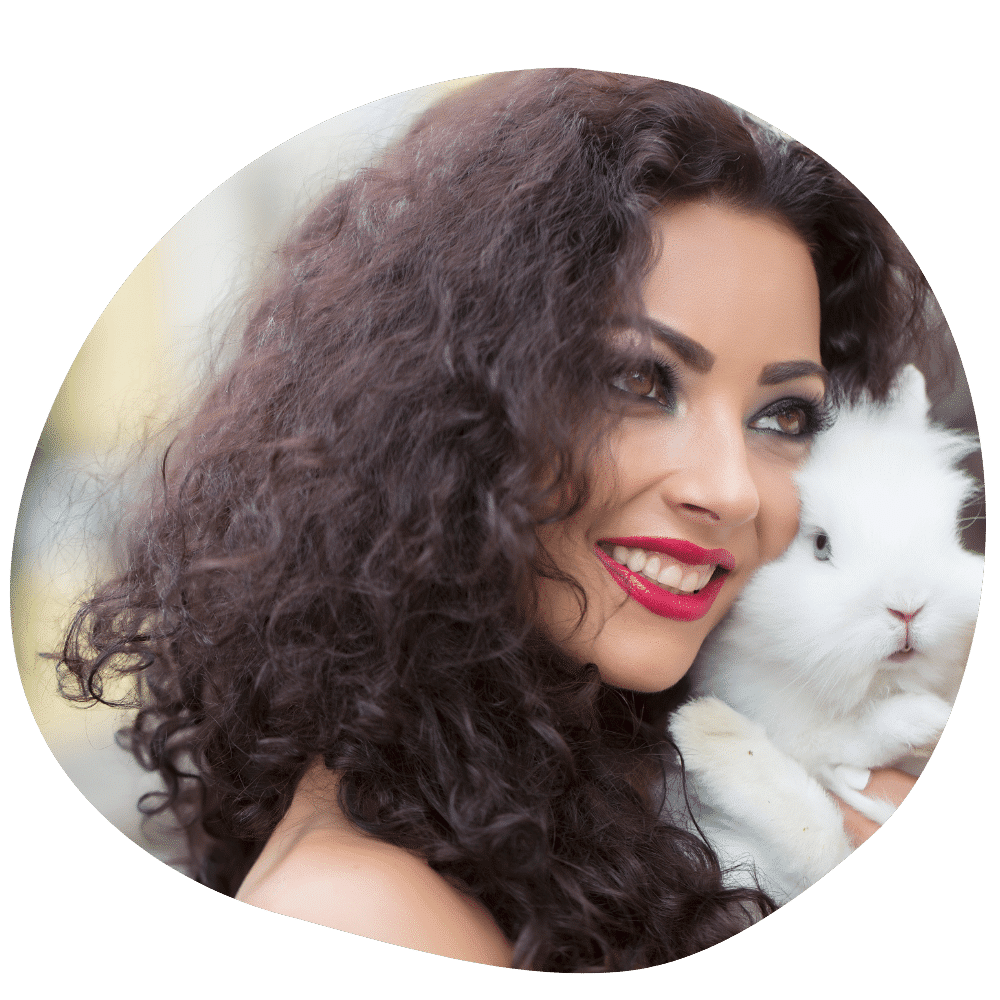 Curly haired rabbit owner holding a fluffy white rabbit in her hand after booking pet sitting services in Abu Dhabi