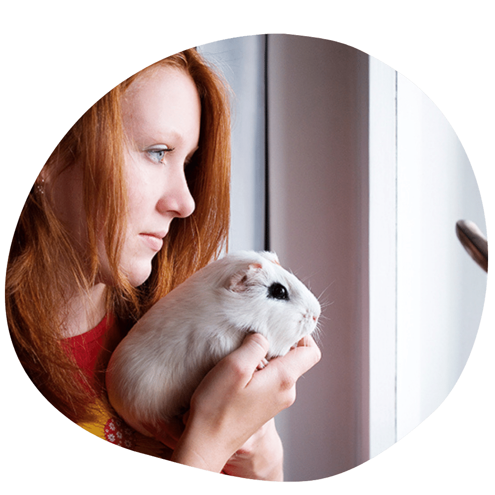 Female guinea pig parent wearing red t-shirt holding guinea pig after pet sitter service in Dubai
