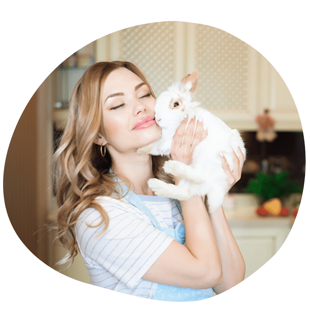 Smiling lady wearing white t-shirt holding fluffy white rabbit after Pawland’s rabbit sitting & boarding