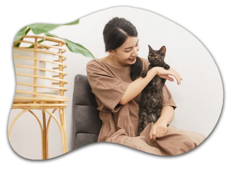 A female cat sitter of pawland holding a cat standing with her hand