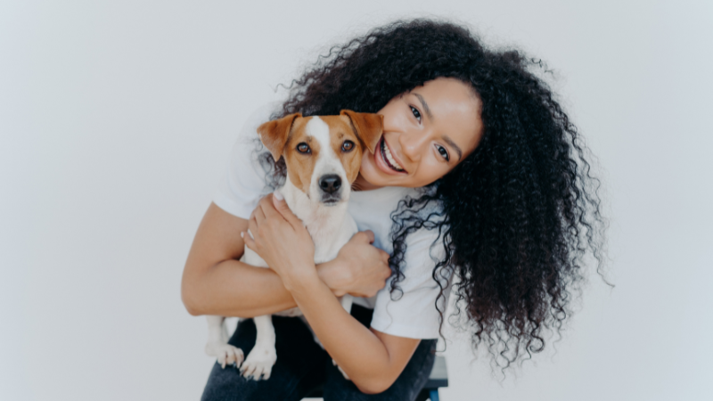 Dog sitter happily holding a small dog during pet care session