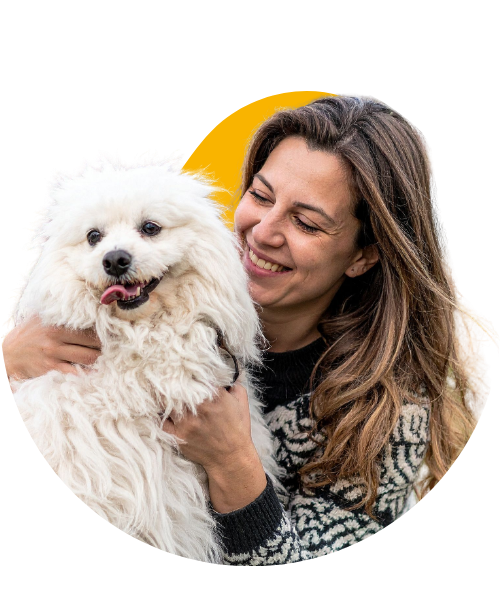 Happy pet parent enjoying a joyful moment with her white dog.