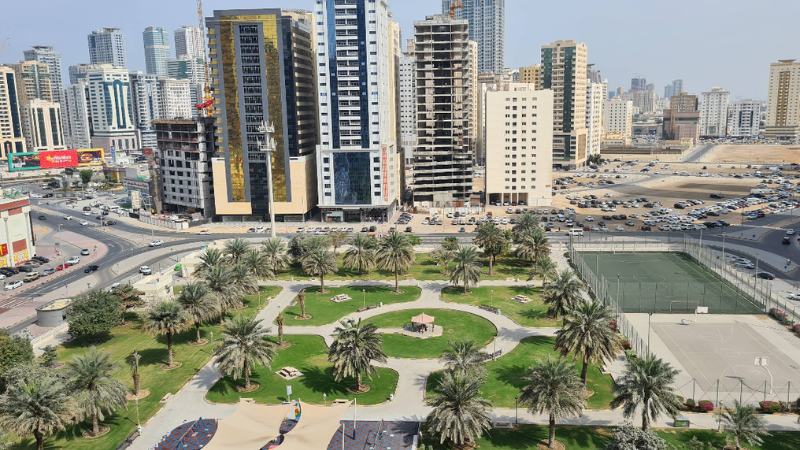 Beautiful view of Al Nahda Park Sharjah with trees, lake, and walking track