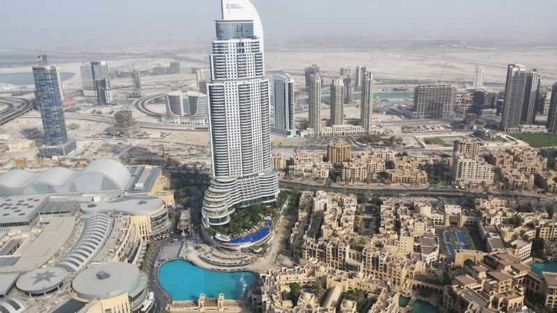 Panoramic view of Downtown Dubai skyline from Burj Khalifa observation deck featuring Burj Lake, Dubai Mall and towers