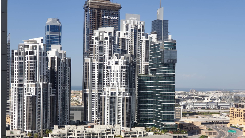 DAMAC building alongside neighboring towers in an eye-level view at Business Bay Dubai showcasing modern skyline and urban architecture