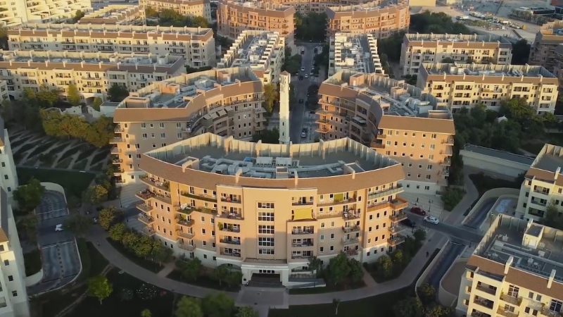 Aerial view of Motor City featuring wide roads and large modern buildings, showcasing urban planning and residential community in Dubai