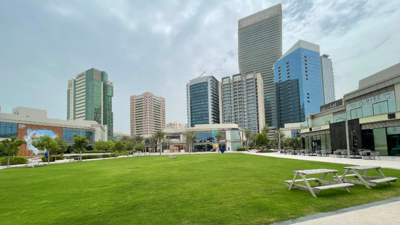 Sheikha Fatima Park full green landscape with seating tables, peaceful garden setting, and open space for relaxation and visitors