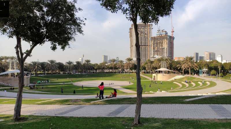 People walking and relaxing inside Zabeel Park in Dubai, enjoying greenery, open space, and a peaceful outdoor environment