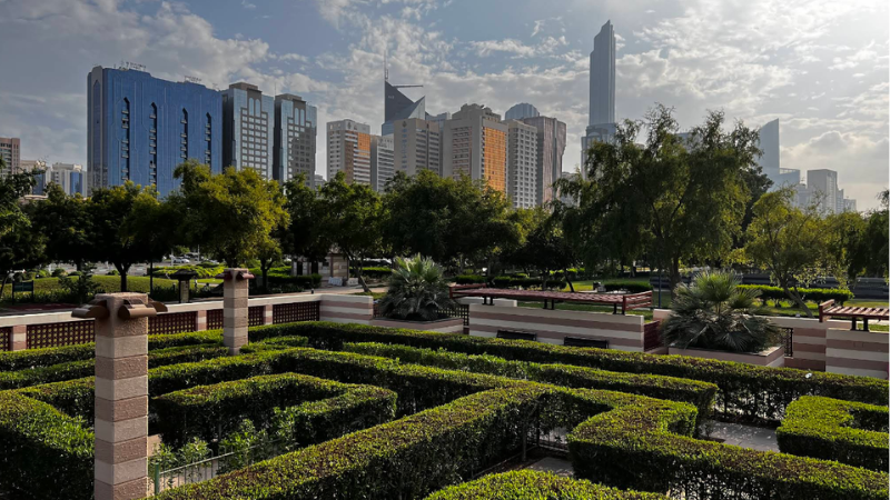Formal park full view with people walking, relaxing, and visiting in a well-maintained landscaped garden setting