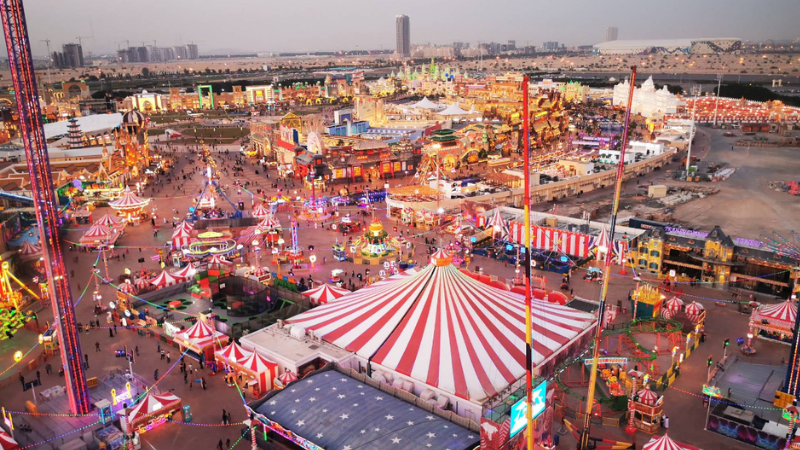 Full view of Global Village Dubai at night with colorful lights and attractions.