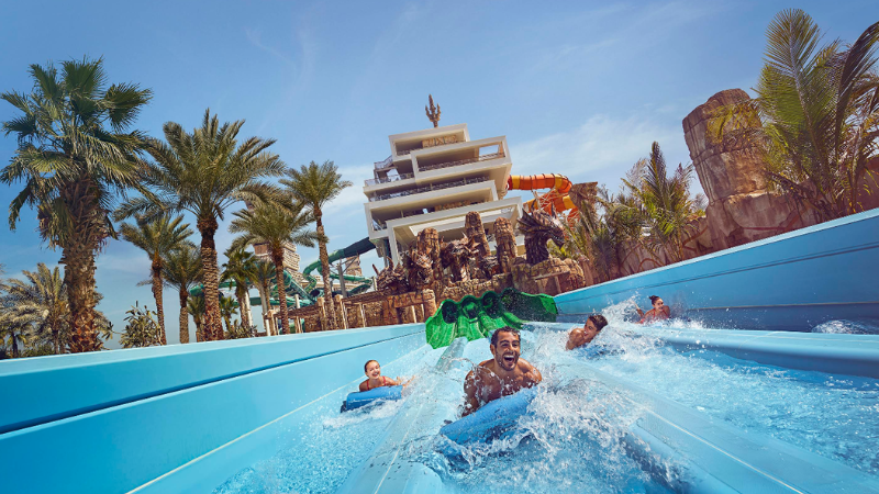Visitors jumping into the water at Aquaventure World Dubai during an exciting water adventure.