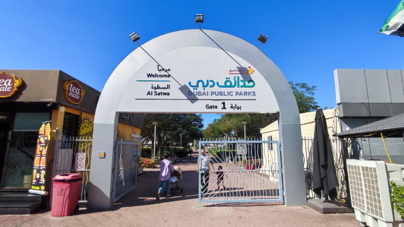 Gate 1 of Satwa Park in Dubai with visitors and a coffee shop.