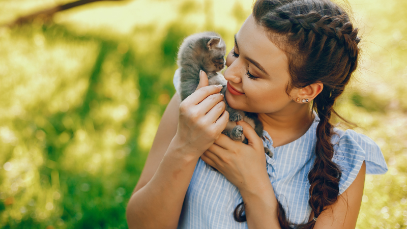 Female cat owner holding her pet cat in her arms
