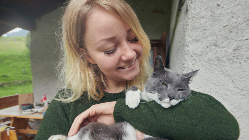 Woman cuddling her beloved pet cat indoors